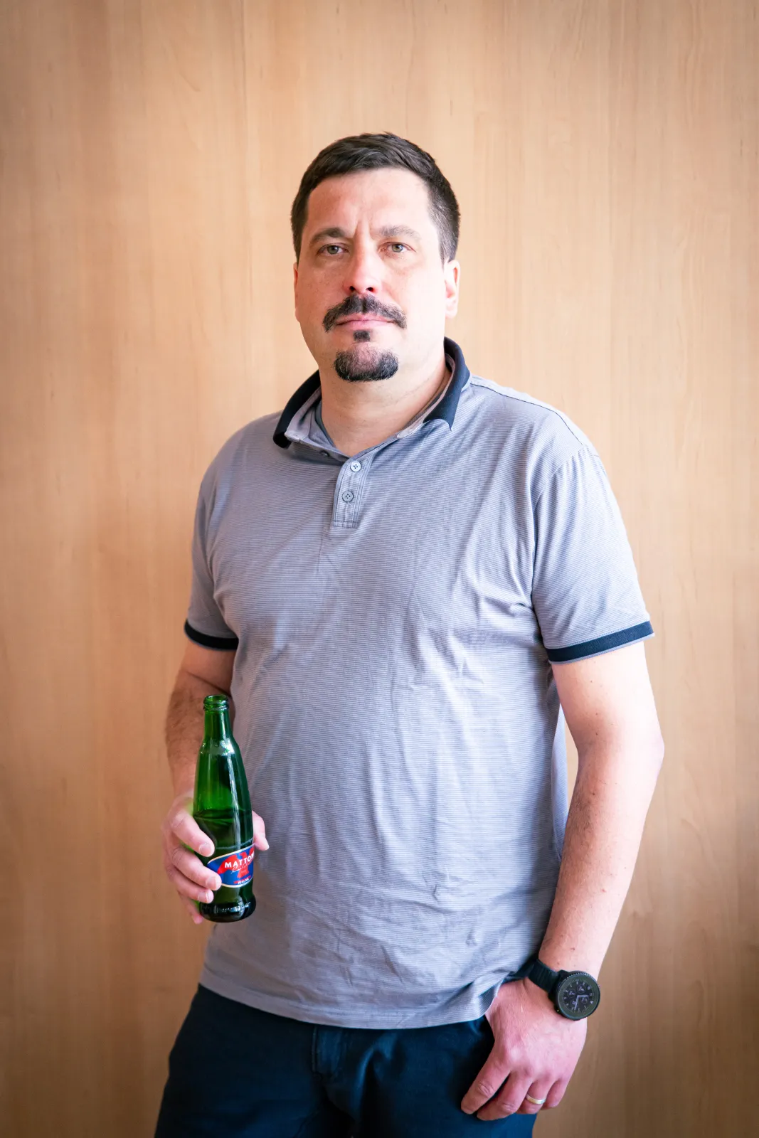 Jan Medek, Group HR Director ve společnosti Mattoni 1873, v pražských kancelářích na Palmovce — modré tričko s límečkem, lahev Mattoni v ruce. Z natáčení 16. dílu HR Vibecheck od VERYGUD.